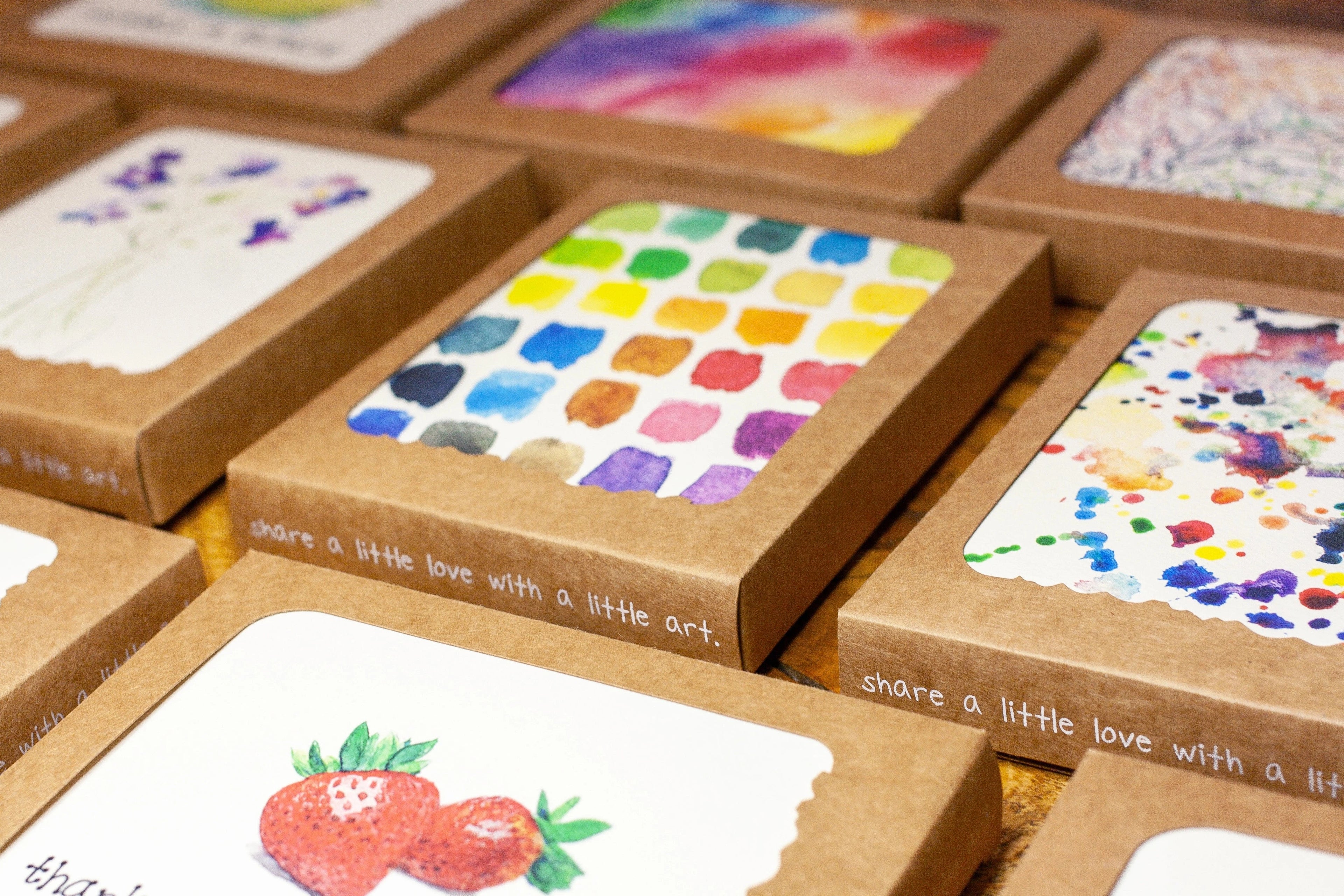 Colorful greeting cards in Kraft boxes arranged side-by-side