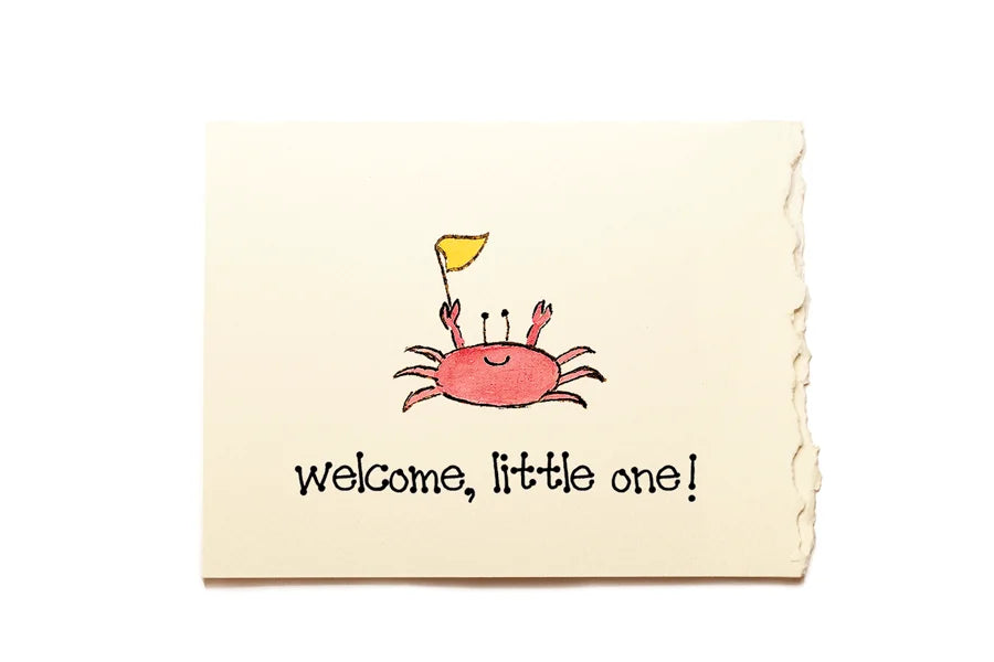 Newborn blanket with a cartoon crab and 'welcome, little one!' text on a beige background