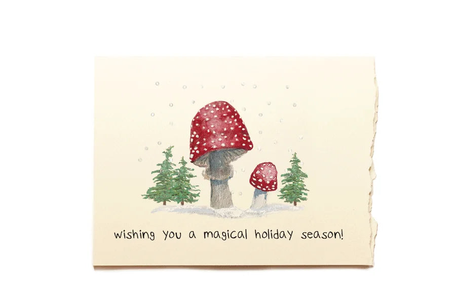Greeting card with mushrooms and trees illustration and text 'Wishing you a magical holiday season!' on a white background.