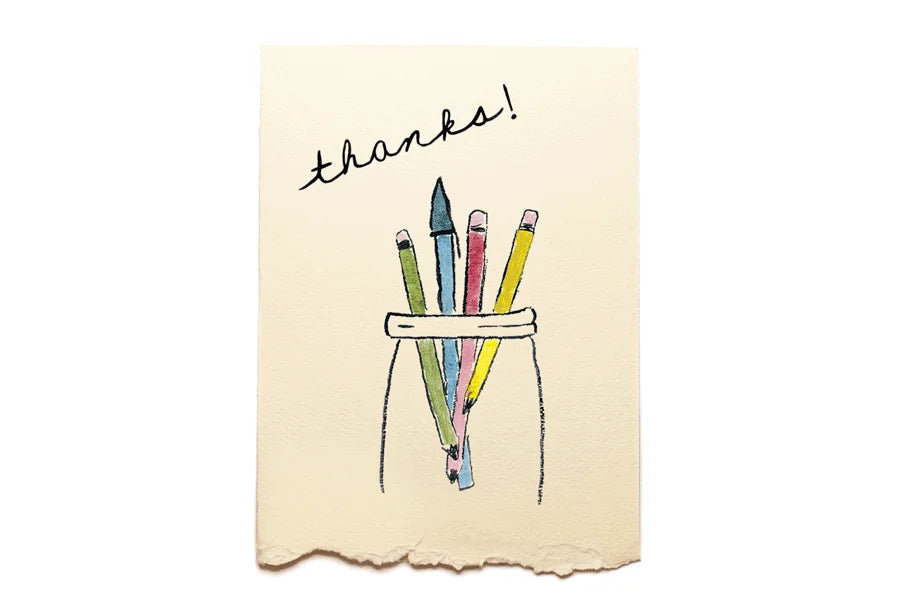 Card with colorful pencils in a bag and 'thanks!' text on a beige background