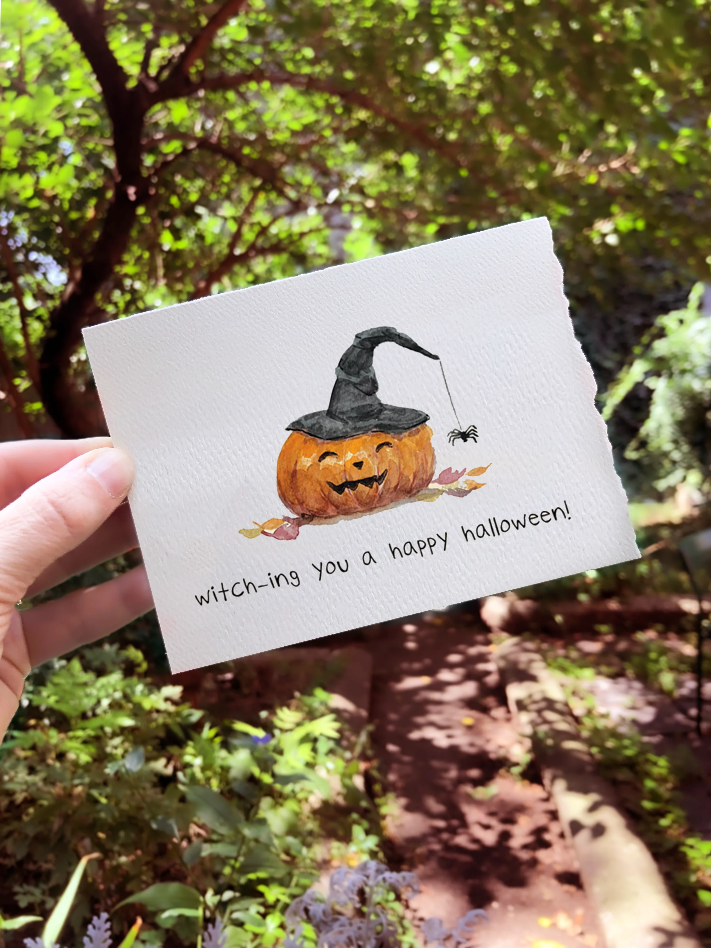 Greeting card with jack-o-lantern held up outside