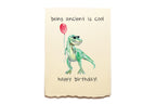 Dinosaur holding a red balloon with text 'being ancient is cool happy birthday!' on a beige background