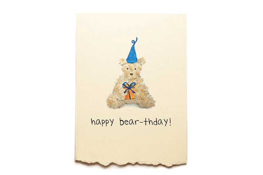 Greeting card with a teddy bear wearing a party hat and bow tie, and text 'happy bear-thday!' on a beige background.