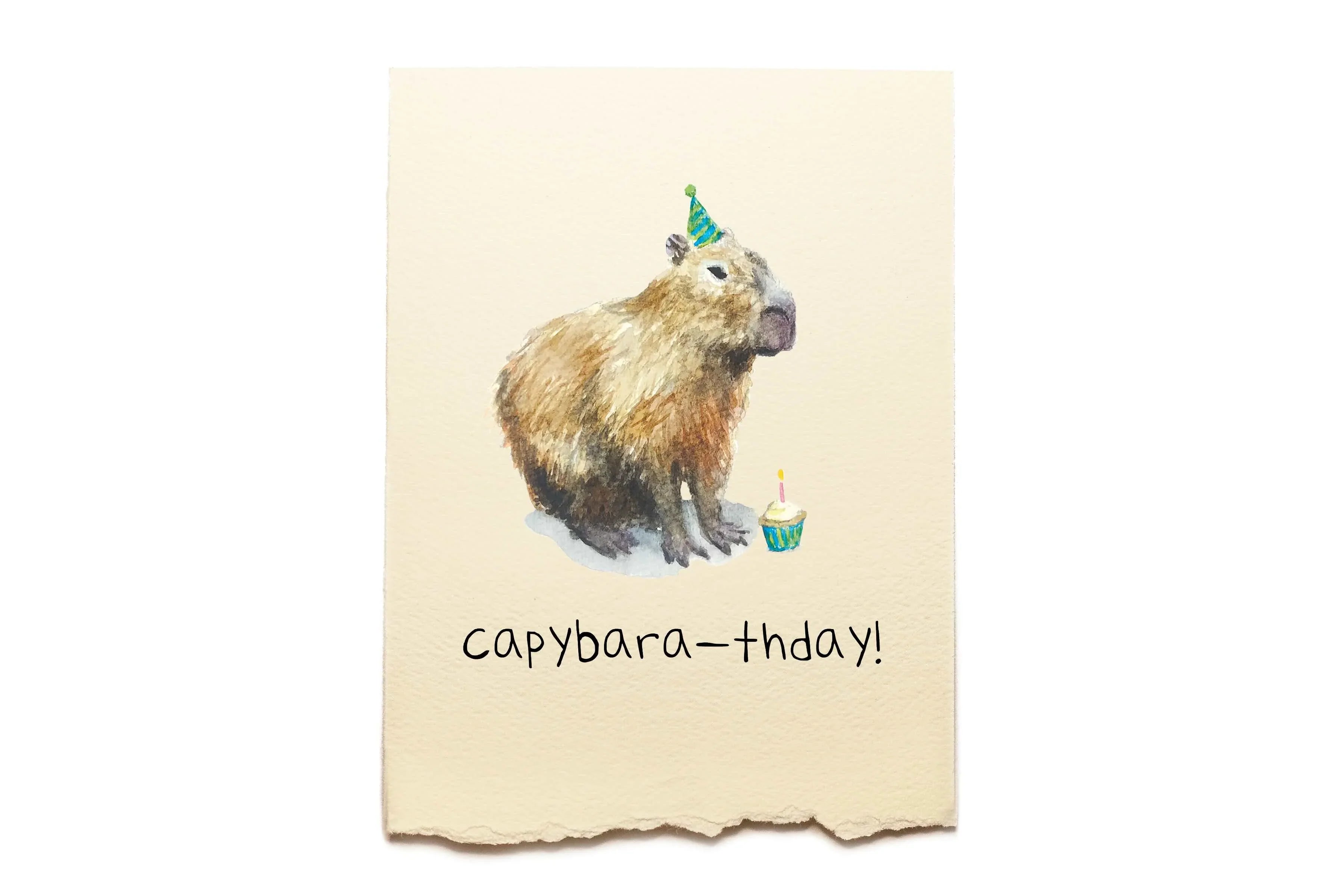 Capybara wearing a birthday hat with 'capybara-thday!' text on a beige background