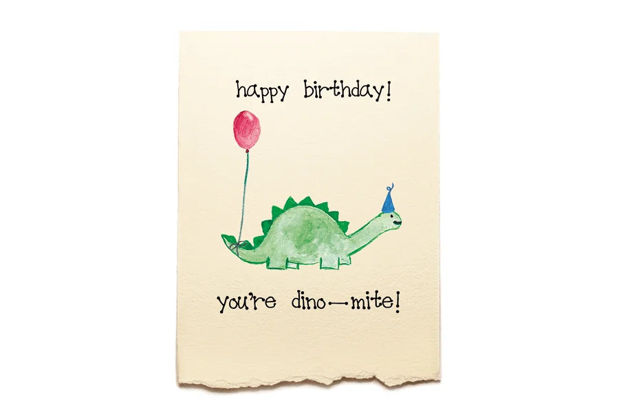 Birthday card with a dinosaur holding a balloon and text 'happy birthday! you're dino-mite!' on a beige background