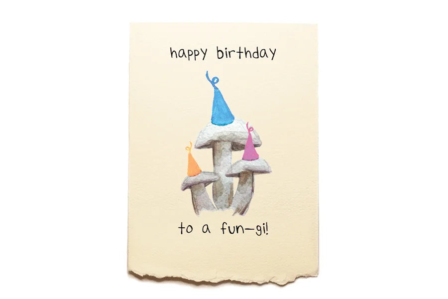 Birthday card with mushrooms wearing party hats and candles on a beige background