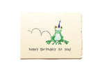 Birthday card with a green frog wearing a purple hat and 'hoppy birthday to you!' text on a beige background.