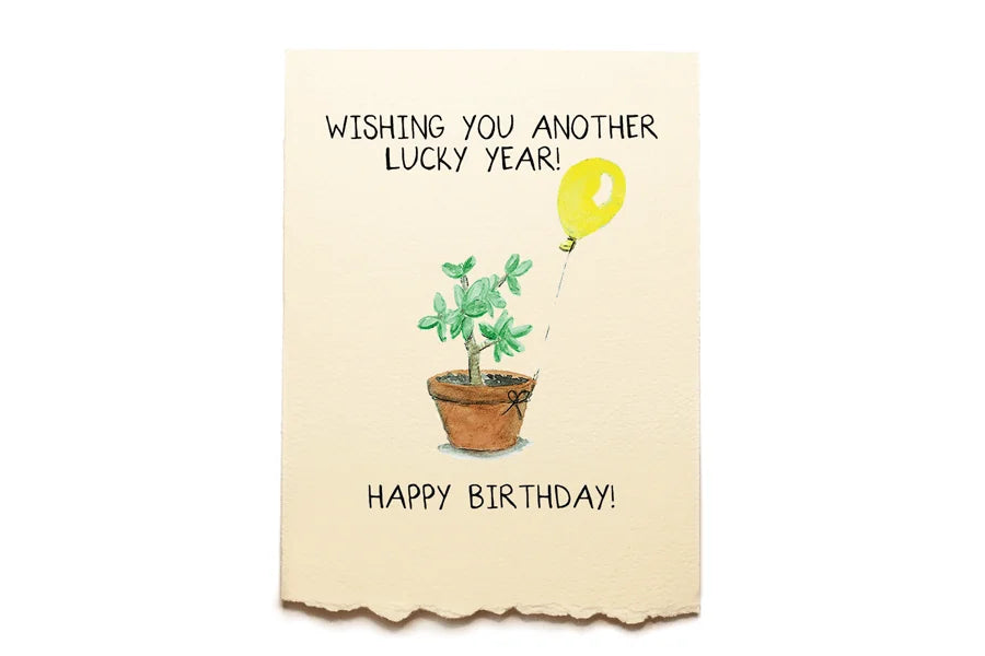 Birthday card with a cactus and yellow balloon on a beige background