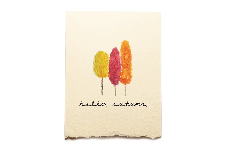 Beige towel with autumn-themed design and 'hello, autumn!' text on a white background