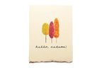 Beige towel with autumn-themed design and 'hello, autumn!' text on a white background