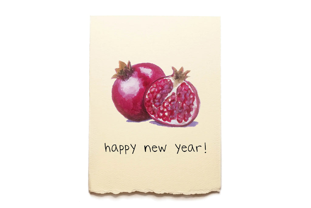 Card with pomegranates and 'happy new year!' text on a beige background