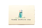 Greeting card with a blue cup and straws illustration and 'Happy Father's Day' text on a beige background.