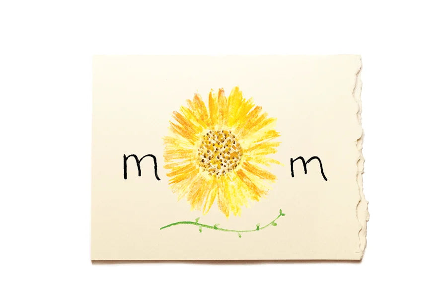 Notebook with a yellow sunflower illustration and 'mom' text on a white background