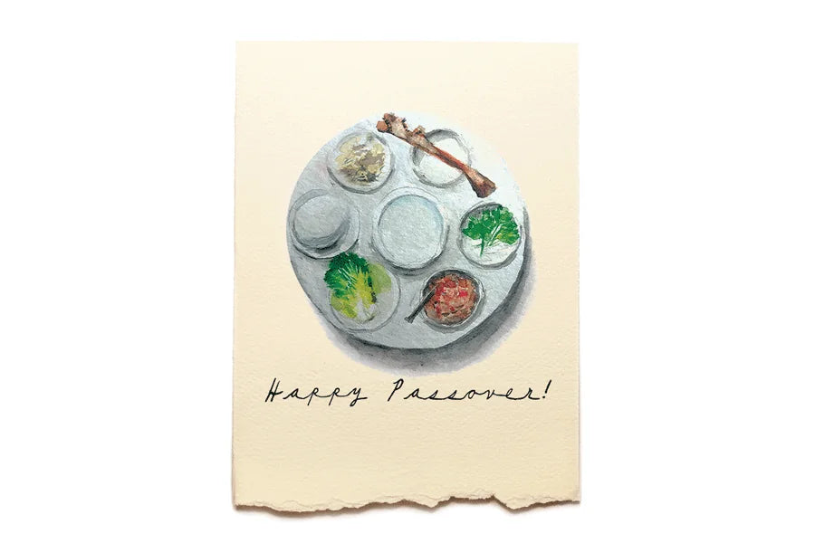 Seder plate with Passover food on a textured paper background