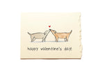 Valentine's Day card with two dogs kissing and a heart above them on a beige background with the text "Happy Valentine's day!".