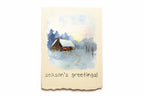 Greeting Card with a winter scene with a cabin and 'season's greetings!' text on a beige card.