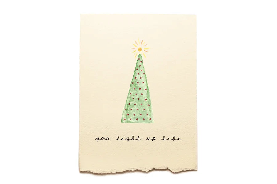 Card with a green Christmas tree and text on a beige background