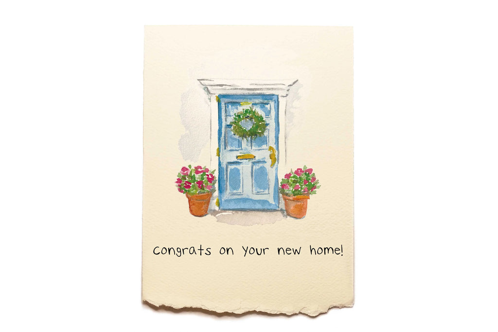 Greeting card with a blue door, wreath, and potted plants on a beige background.