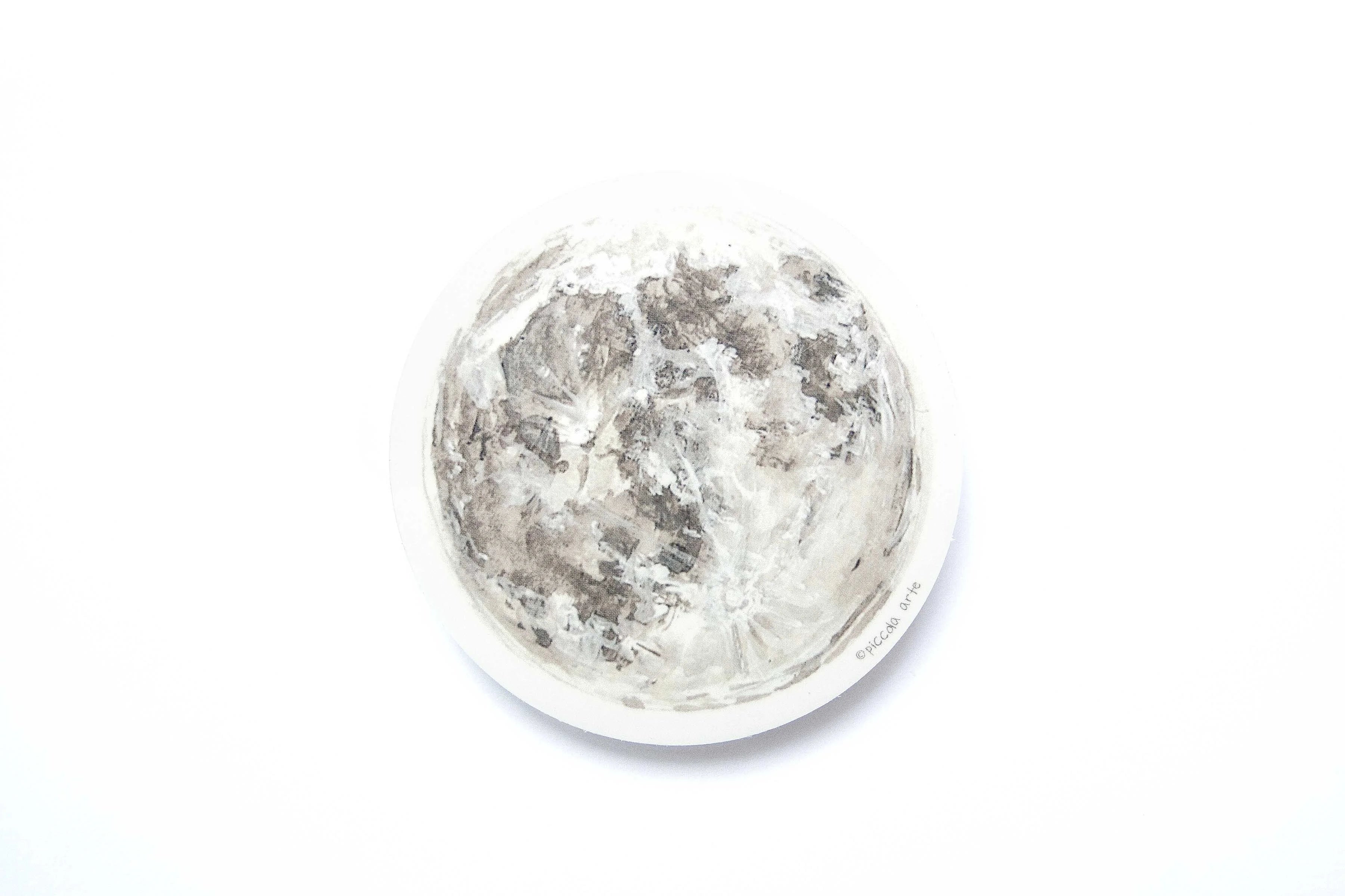 Close-up of a moon-shaped sticker on a white background.