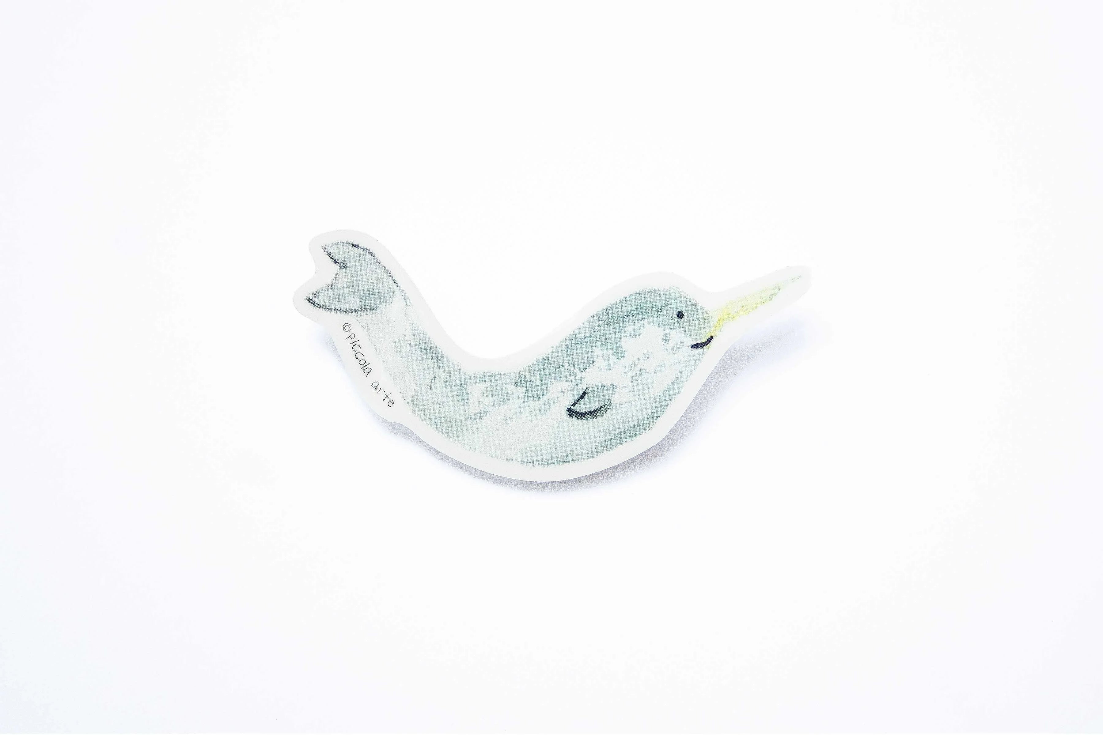 Stcker of a narwhal on a white background.
