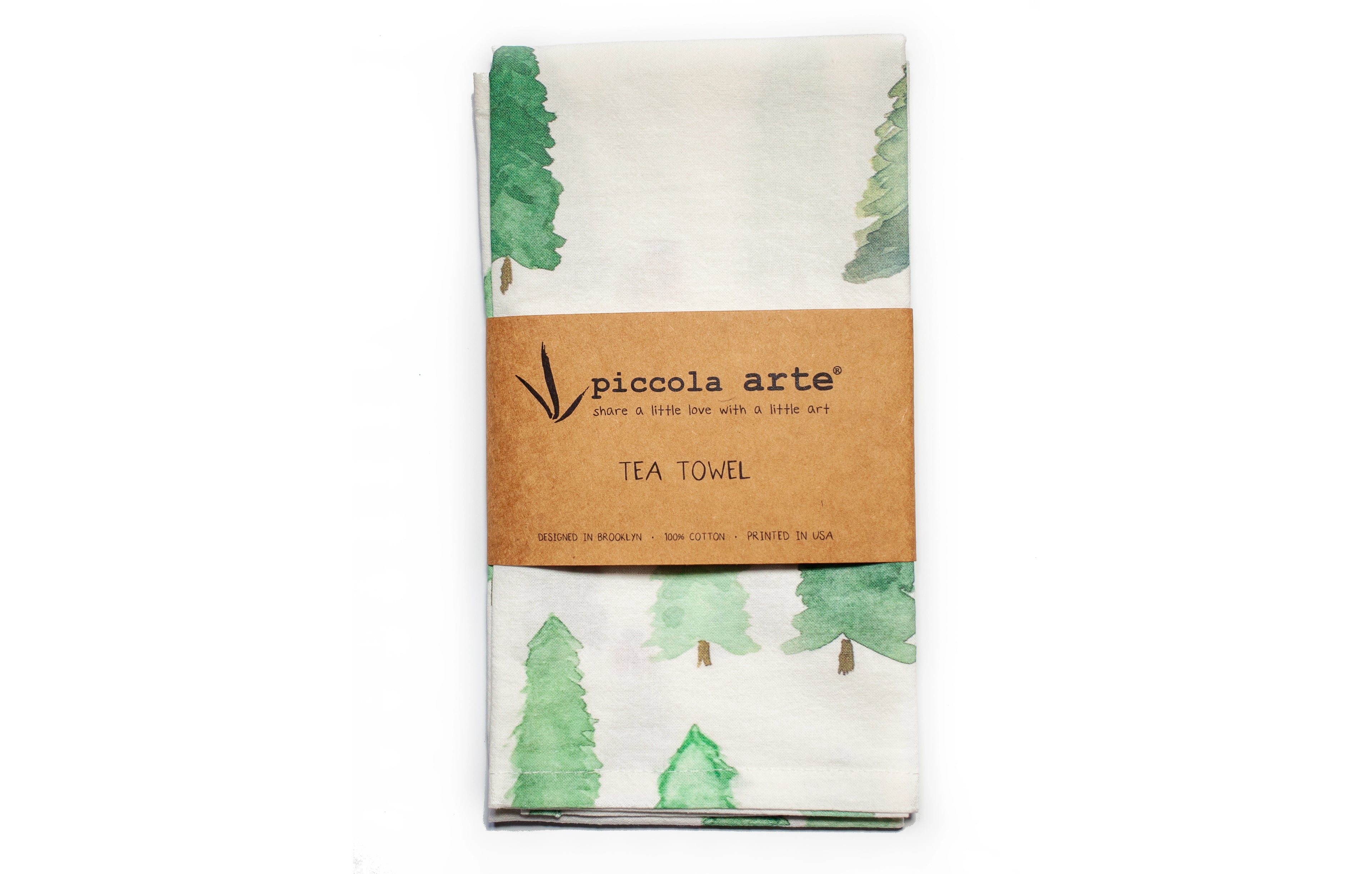 Tea towel with green tree pattern and Piccola Arte label on a white background