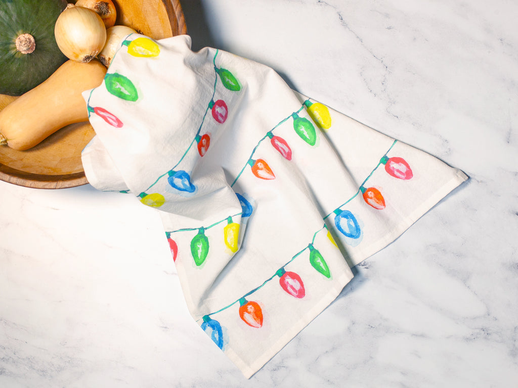 Napkins with colorful light bulb pattern on a marble surface with pumpkins.