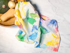 Colorful towel with watercolor design on a marble surface with fruits.