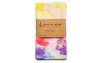 Tea towel with watercolor design and 'piccola arte' branding on a white background