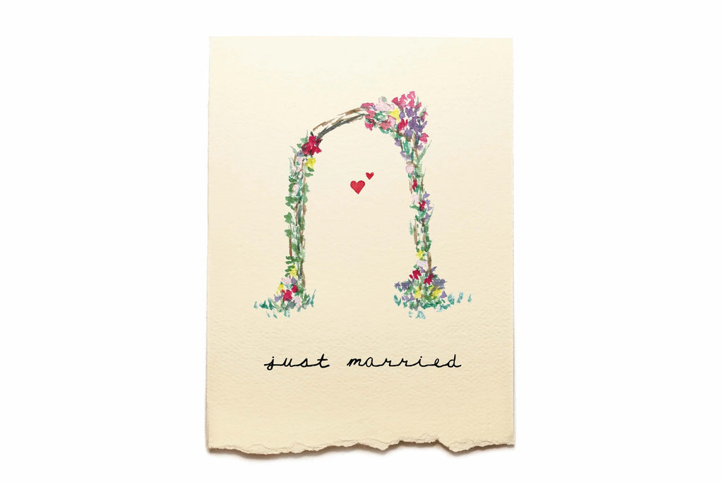 Floral arch with 'just married' text on a beige background