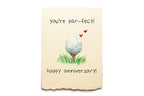 Greeting card with golf ball on a tee, hearts, and text 'you're par-fect! happy anniversary!' on a beige background.