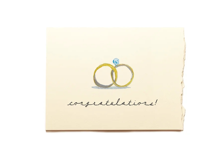 Greeting card with wedding rings and 'congratulations!' text on a beige background